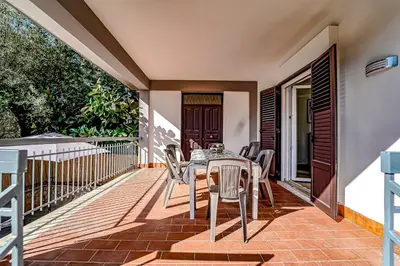 a patio with a table and chairs on a deck at Lovely Villa, close to the beach in Palermo
