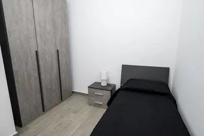 a bedroom with a black bed and a night stand at AVA VACATION HOME in Borgetto