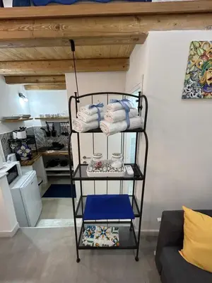 a towel rack with towels on it in a room at Palermo home cathedral apartment in Palermo
