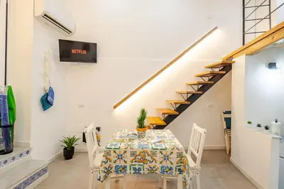 a dining room with a table and a staircase at Palermo home cathedral apartment in Palermo