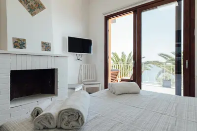 a bedroom with a bed with a fireplace and a tv at Appartamento in Villa con accesso al mare, vista mozzafiato in Palermo