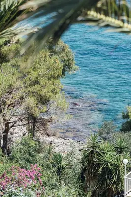 a view of a body of water with trees and flowers at Appartamento in Villa con accesso al mare, vista mozzafiato in Palermo