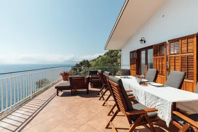 a balcony with a table and chairs and the ocean at Appartamento in Villa con accesso al mare, vista mozzafiato in Palermo