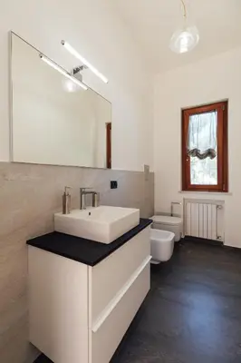 a bathroom with a sink and a mirror and a toilet at Appartamento in Villa con accesso al mare, vista mozzafiato in Palermo