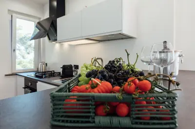 a basket of fruits and vegetables on a counter in a kitchen at Appartamento in Villa con accesso al mare, vista mozzafiato in Palermo