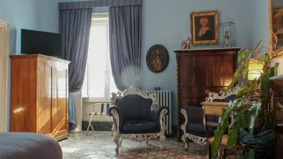 a room with two chairs and a desk and a window at Donna Guia suite in Palermo