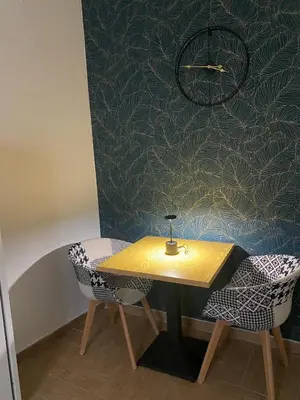 a table and two chairs in a room with a wall at Maqueda Suite Palermo at Cathedral in Palermo