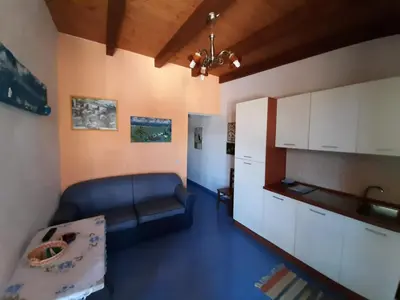 a living room with a couch and a kitchen at Villetta Edera all'Usciere in San Vito lo Capo