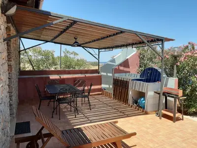 a wooden deck with a table and chairs on it at Villetta Edera all'Usciere in San Vito lo Capo