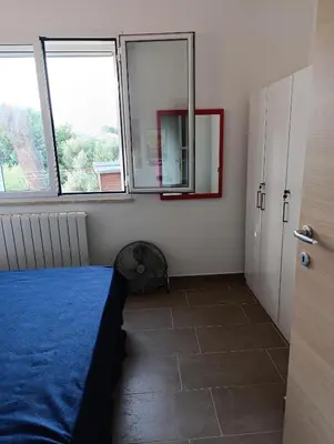 a bedroom with a blue bed and two windows at Villa Casa di Franca - 700 meters from the sea Scopello in Castellammare del Golfo