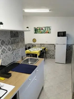 a kitchen with a sink and a table with chairs at La Loggia 34 in Palermo