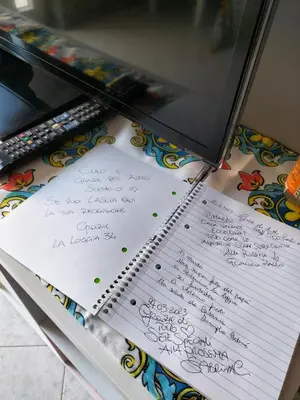 a notebook with handwriting on it next to a laptop at La Loggia 34 in Palermo