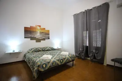 a small bedroom with a bed and a window at ZU' NICOLA in Palermo