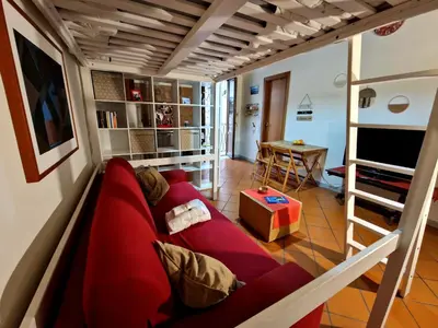 a living room with a red couch and a bunk bed at Old Town Loft - Palermo in Palermo