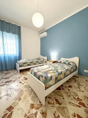 two beds in a room with blue walls at Casa Indipendenza - Cattedrale in Palermo