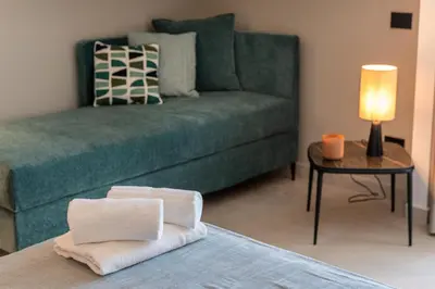 a living room with a green couch and a table at Limen Wellness Hotel & Spa in Campofelice di Roccella