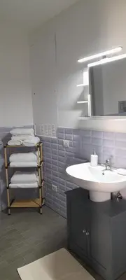 a bathroom with a sink and a mirror and towels at BALLARHOUSE in Palermo