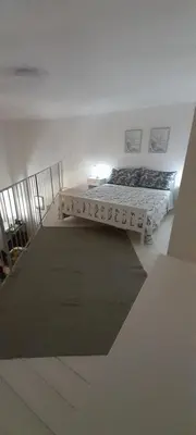 two beds in a white room with a rug at BALLARHOUSE in Palermo