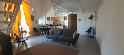 a living room with a couch and a kitchen at BALLARHOUSE in Palermo