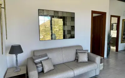 a living room with a couch and a picture on the wall at Villa Felice - SEAVIEWS & PRIVATE POOL in Scopello