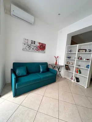 a living room with a blue couch and a table at Leam Apartment 5 in Palermo