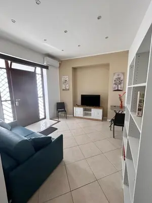 a living room with a blue couch and a television at Leam Apartment 5 in Palermo