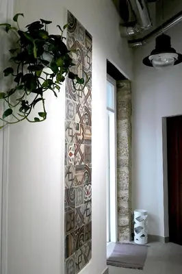 a room with a wall with a mosaic wall at Opera Suites - Aida in Palermo