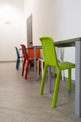 a green chair and tables in a room at Cortile dei Giusti - Combo Guesthouse in Palermo