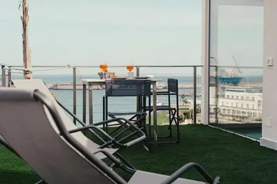 a table and chairs on a balcony with a view of the ocean at TOP OF THE PORT in Palermo