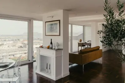 a living room with a piano and a dining room with windows at TOP OF THE PORT in Palermo