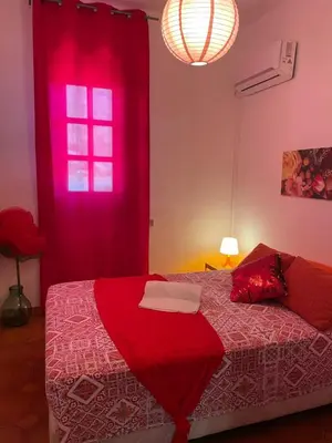 a bedroom with a red bed and a red window at Villa Contrada Sauci in San Vito lo Capo