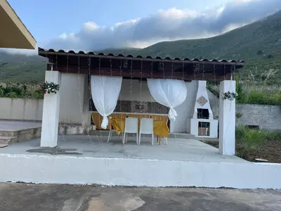 a pavilion with white curtains and tables and chairs at Villa Contrada Sauci in San Vito lo Capo