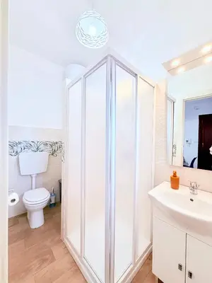 a white bathroom with a toilet and a sink at Casa vacanza CUTÓ in Bagheria