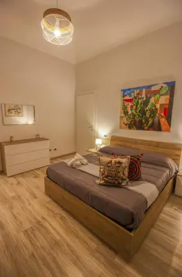 a bedroom with a large bed and a painting on the wall at Quintino 57 Al Politeama - Tourist Lease in Palermo