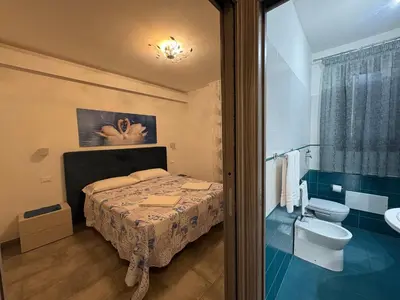 a bathroom with a bed and a toilet and a sink at Casa Diamante in San Vito lo Capo