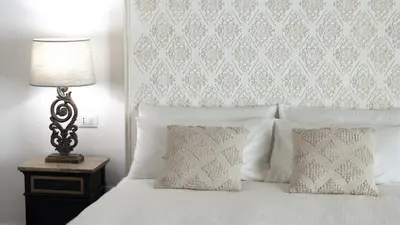 a bed with two pillows and a lamp on a table at Dimora Borghese “Florio” in Palermo