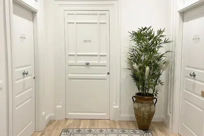 a hallway with a door and a potted plant at Dimora Borghese “Florio” in Palermo