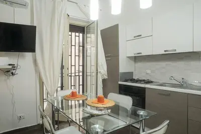 a kitchen with a glass table with two hats on it at 4 Canti Central cozy apt in via Maqueda in Palermo