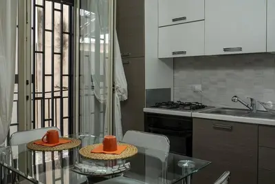 a kitchen with a glass table with two hats on it at 4 Canti Central cozy apt in via Maqueda in Palermo