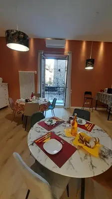 a living room with a table and chairs at Massimo Luxury Rooms in Palermo