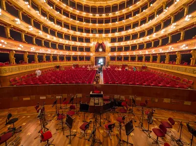 an empty auditorium with red chairs and lights at Massimo Luxury Rooms in Palermo