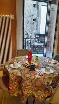 a table with a colorful table cloth on it with a window at Massimo Luxury Rooms in Palermo