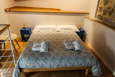 a bedroom with a bed with two pillows on it at Opera Suites - Norma in Palermo