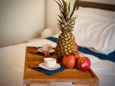 a tray with a pineapple and cups and apples on a bed at 38 HOUSE in Palermo