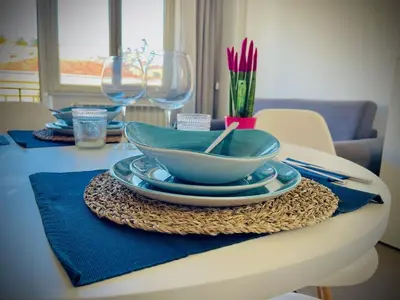 a table with a blue bowl and plates and wine glasses at 38 HOUSE in Palermo
