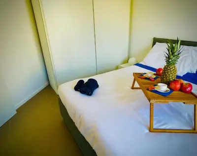 a bed with a table with a tray of fruit on it at 38 HOUSE in Palermo
