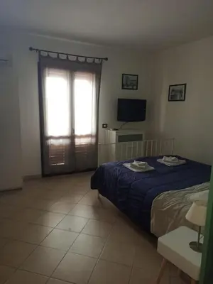 a bedroom with a bed and a window and a television at A terrace in the heart of Palermo in Palermo