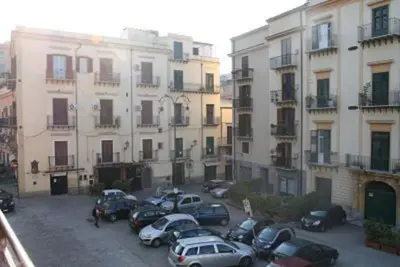 a group of cars parked in a parking lot in front of buildings at A terrace in the heart of Palermo in Palermo