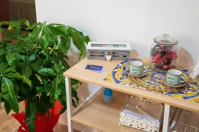 a table with two cups on a plate next to a plant at Mille91 Apartment in Palermo