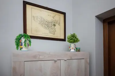 a wooden cabinet with a picture on the wall at Mille91 Apartment in Palermo